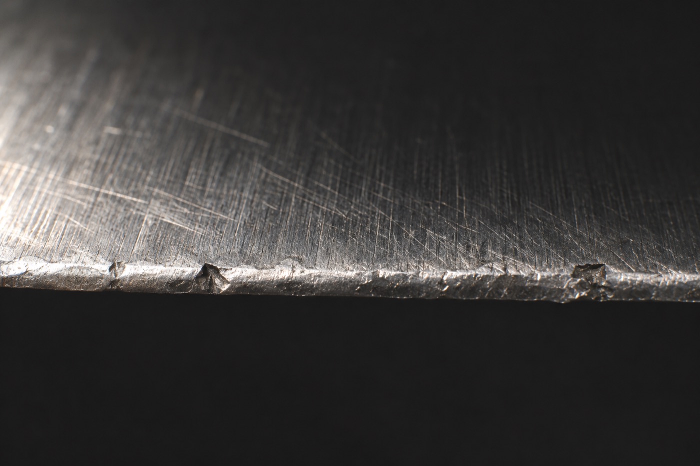 Close-up of a blunt knife edge with chips and a rolled edge